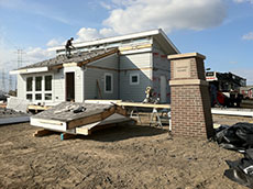 Photo of the INhome being reassembled next to a brick sign that says "Chatham Square."