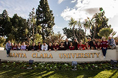 Photo of members of the Santa Clara University Solar Decathlon 2013 team sitting and standing on a pile of construction materials.