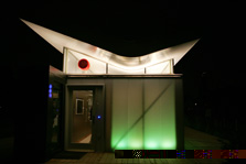 Nighttime photo of a modern-style house that glows from lights within.